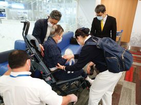 空港に到着した、ボランティアの許麗香（右）は国際医療搬送会社のスタッフ達とAさんの車いすからの移動を手伝います。写真/林真子